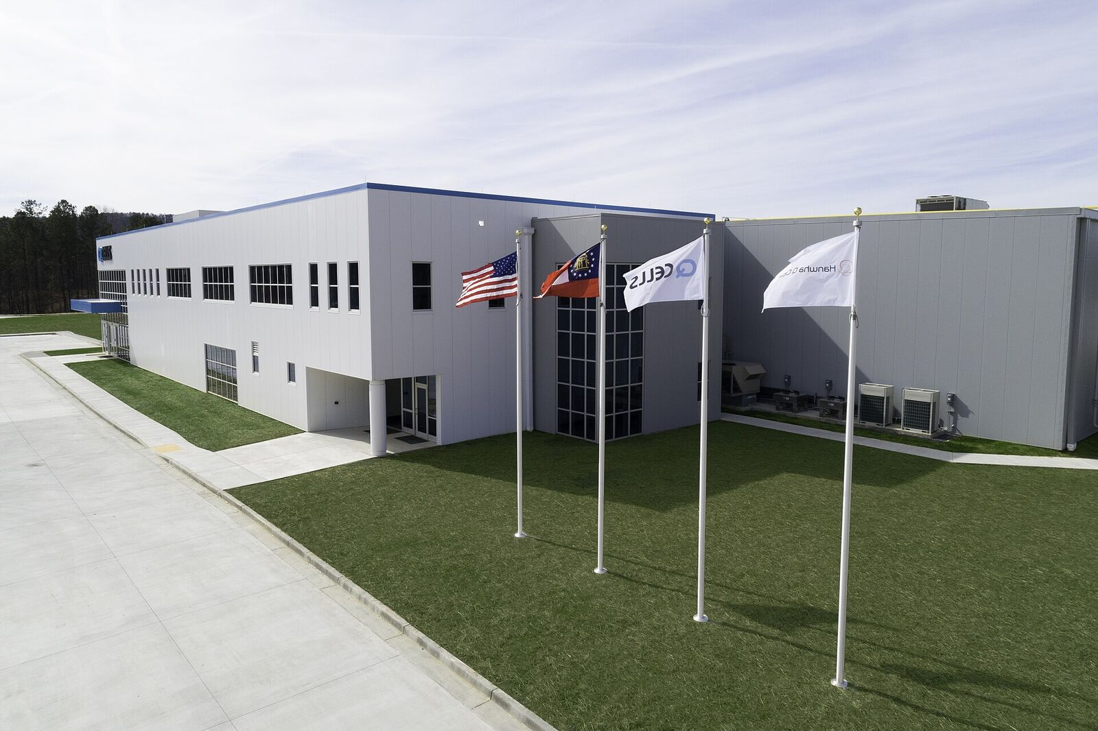 American and Georgia state flags flying at the entrance of the Qcells factory in Dalton, Georgia